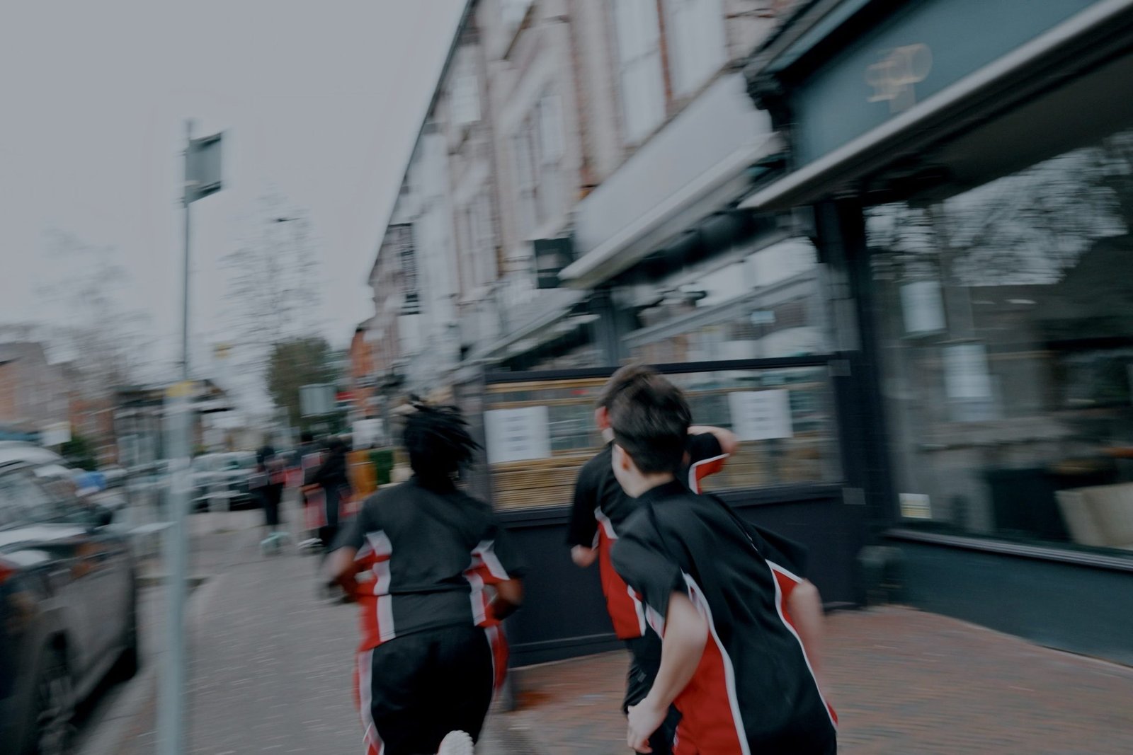 Students in school kit running through town, motion-blurred